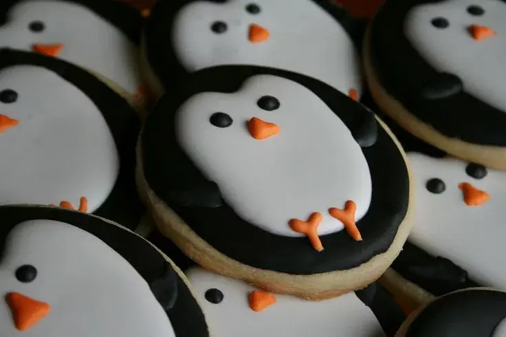 Семья печет пряники в виде пингвинов, идеи празднования 10 января. 