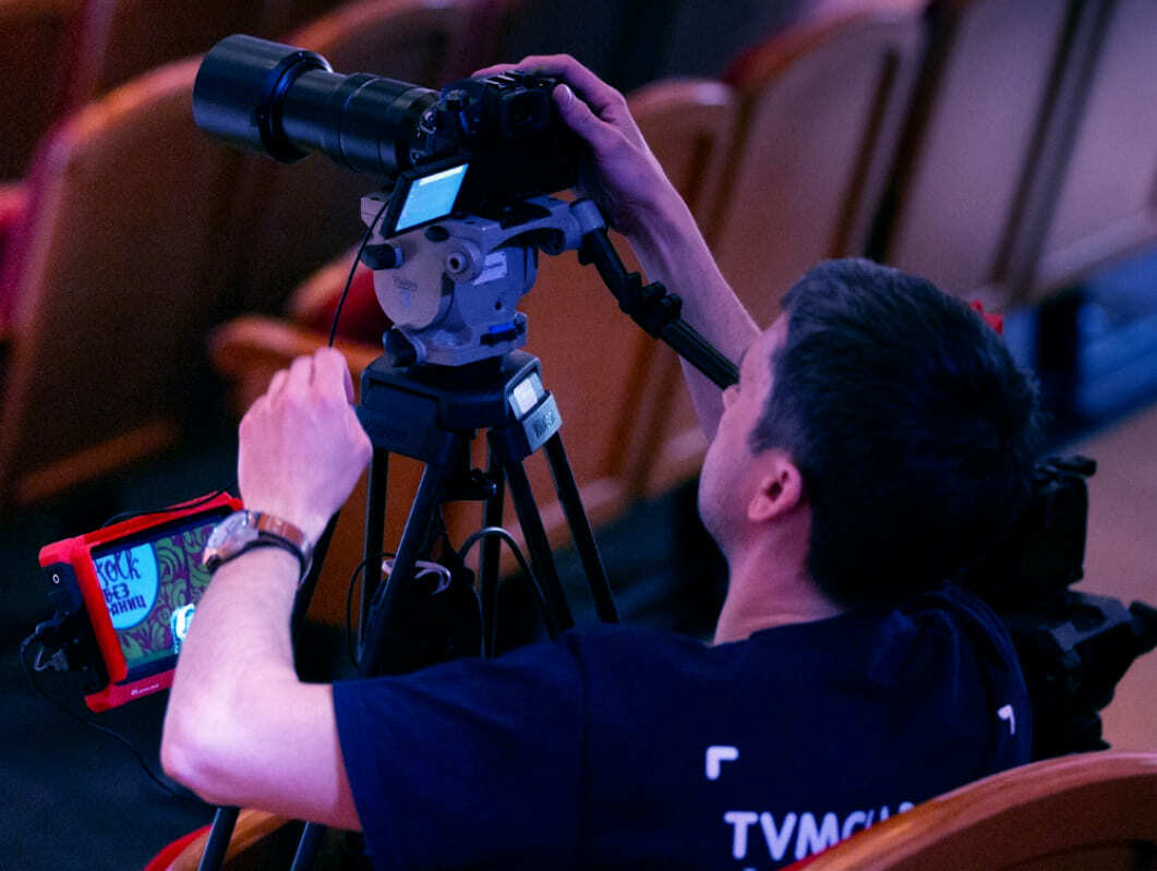 Видеомейкер в процессе видеосъемки концерта