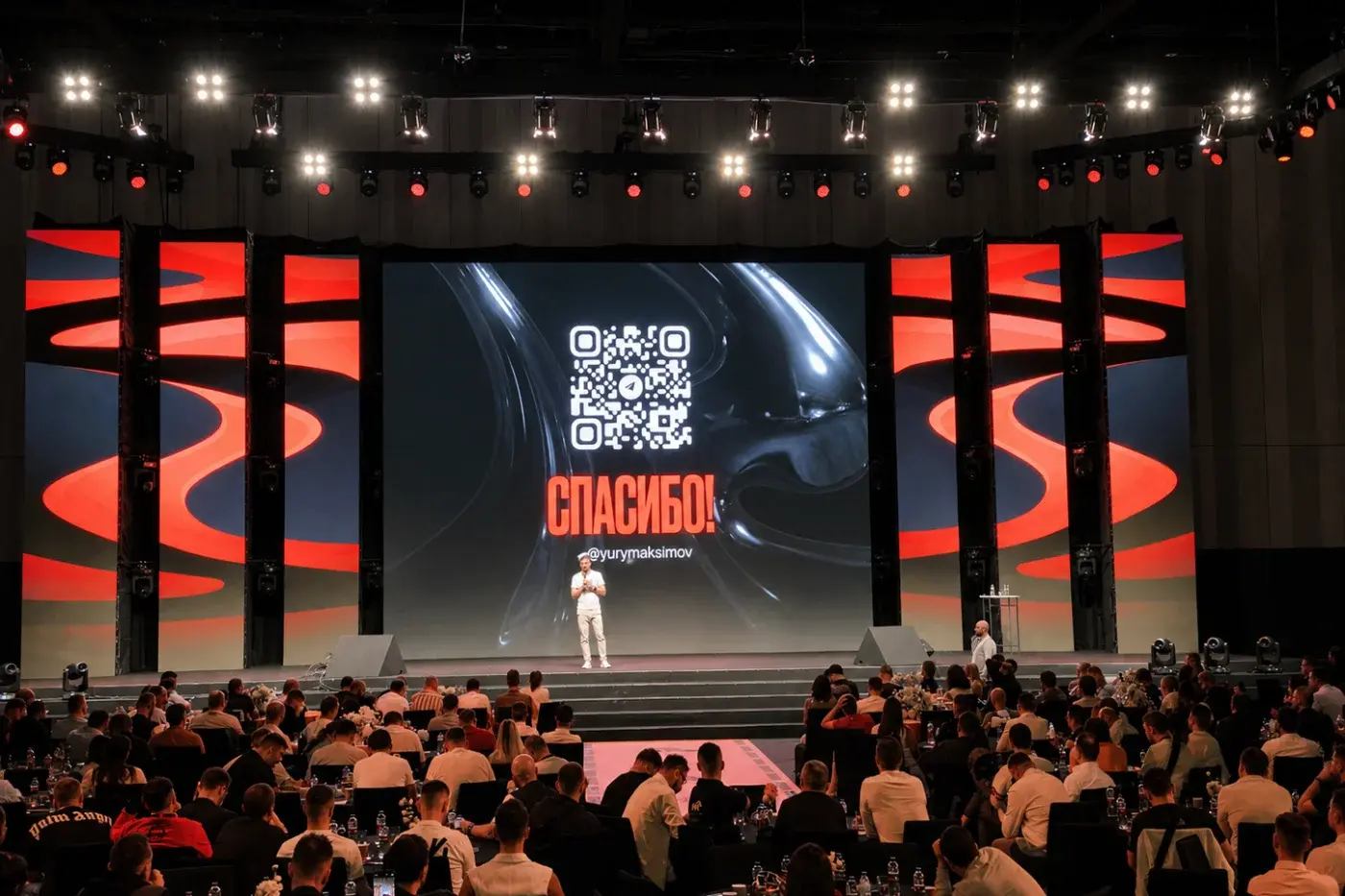 Main stage with a wide LED screen, architectural set and seated audience