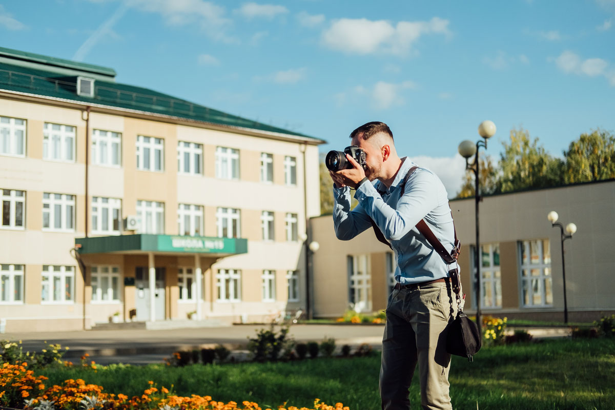 Photographer with camera at school building