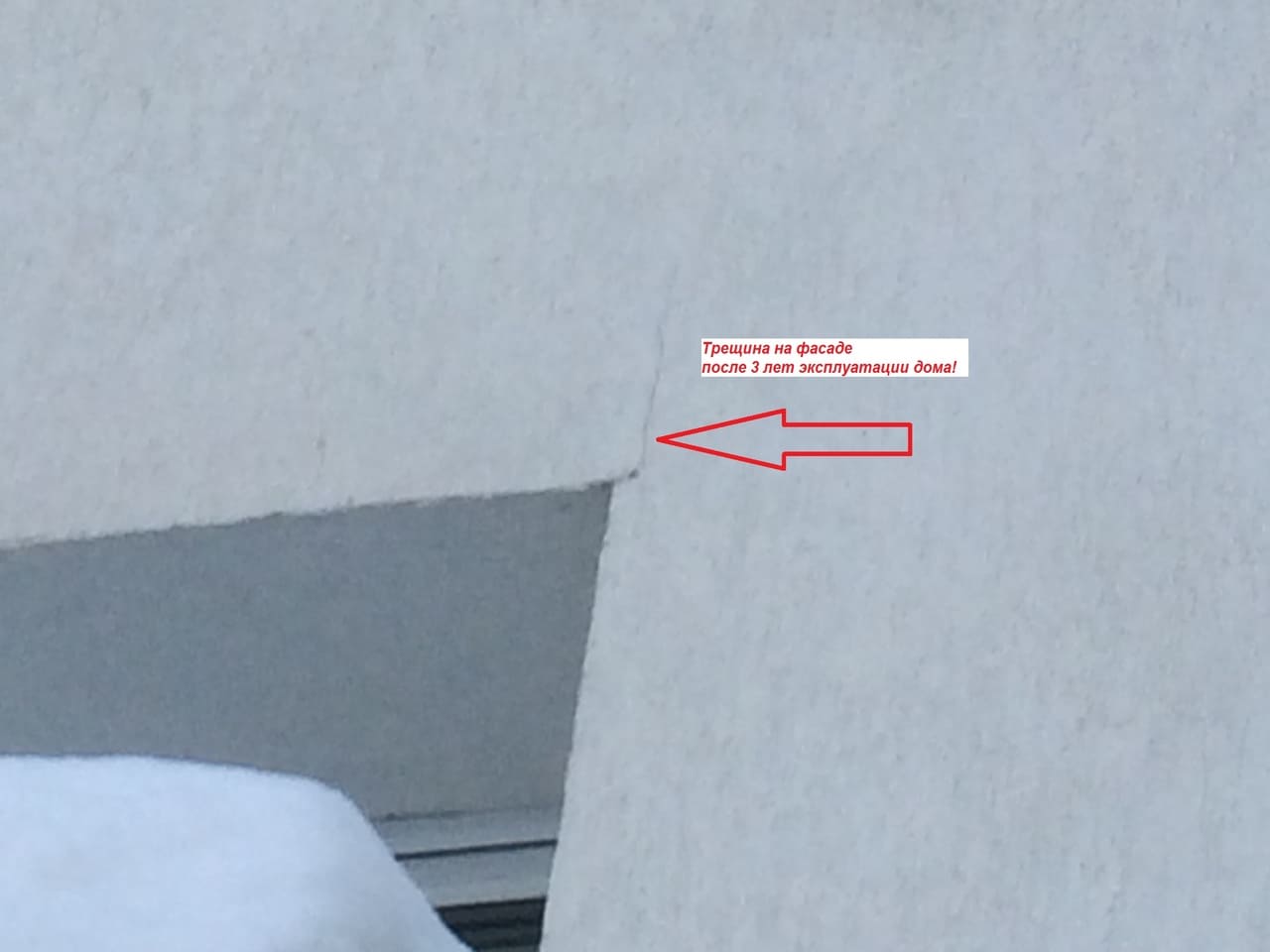 Дефект в виде трещины в углу окна на фасаде жилого дома