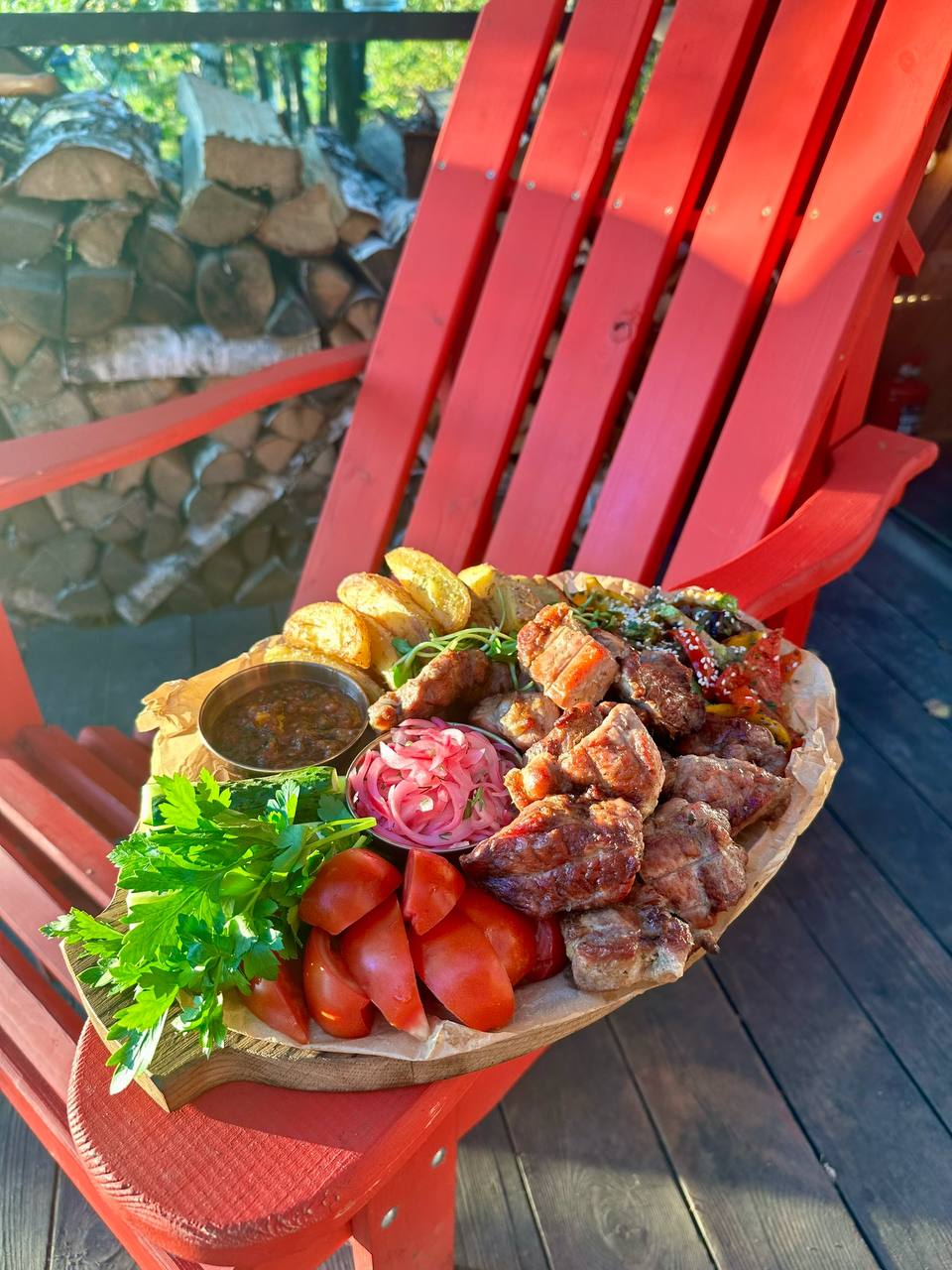 Шашлык с овощами, картофелем и зеленью на террасе