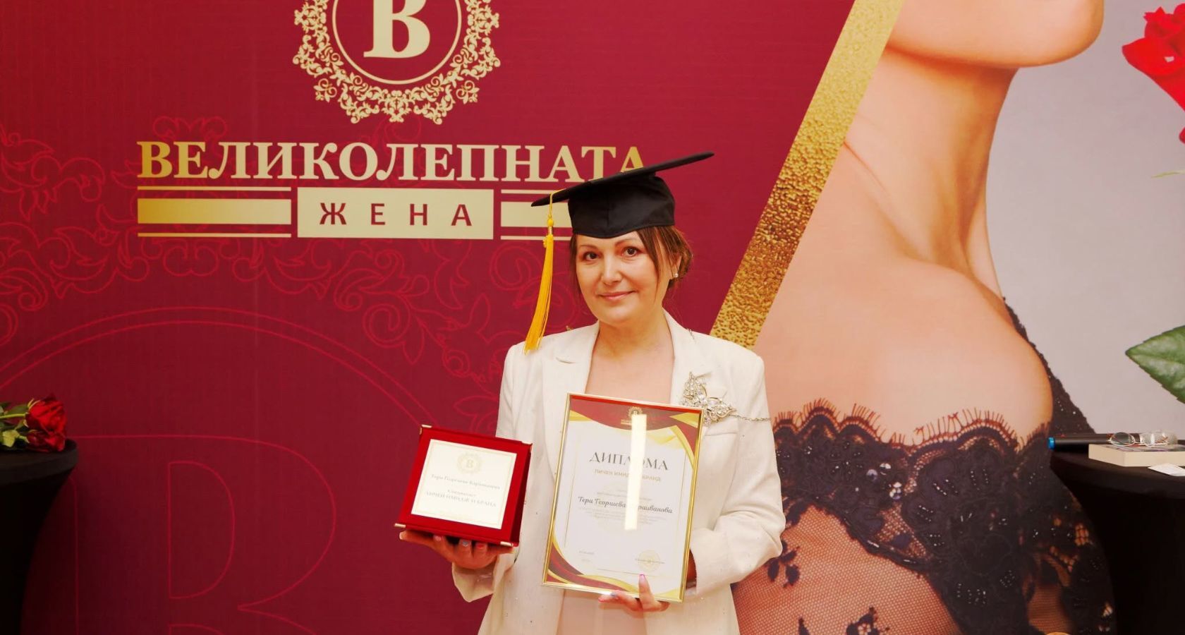 Тери Караиванова позира за снимка със своята диплома за преподавател пред стената на Великолепната Жена на Официалната церемония „Код ВЕЛИКОЛЕПНА