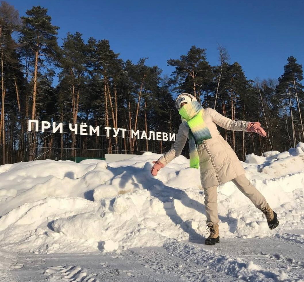 Девушка у надписи «При чём тут Малевич» в зимнем Парке Малевича