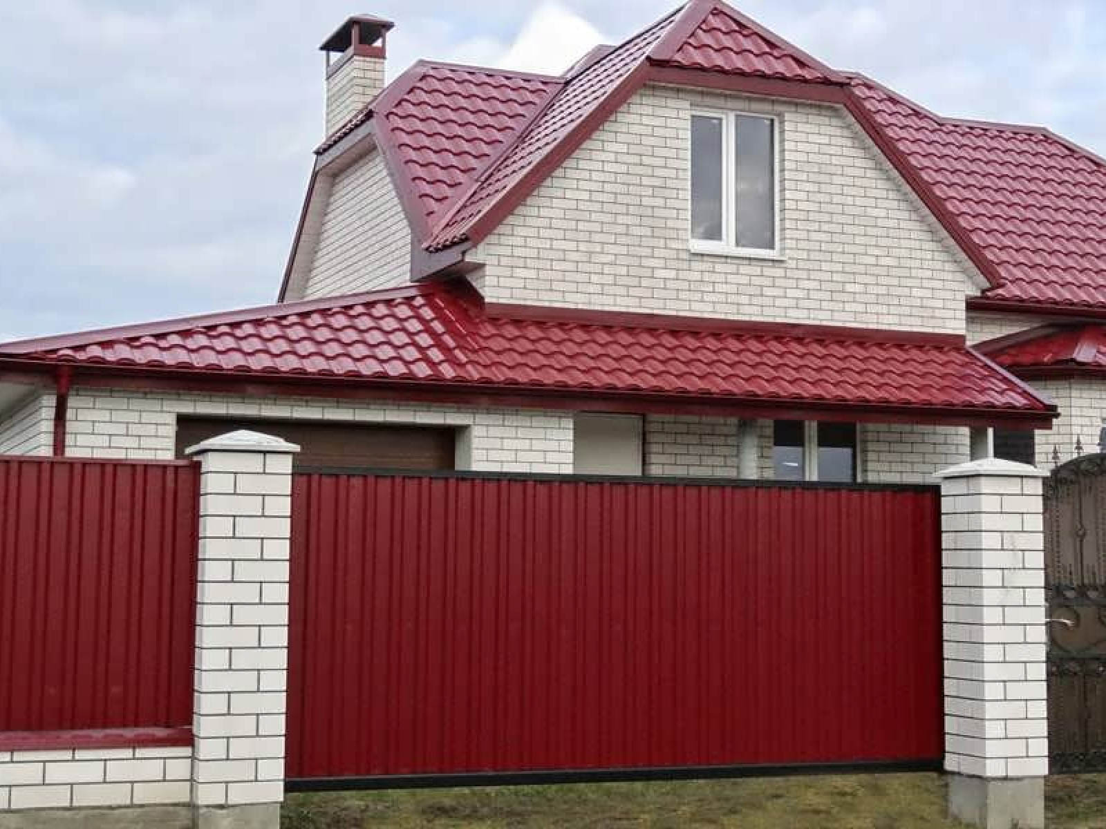 Дом с красной крышей и забором