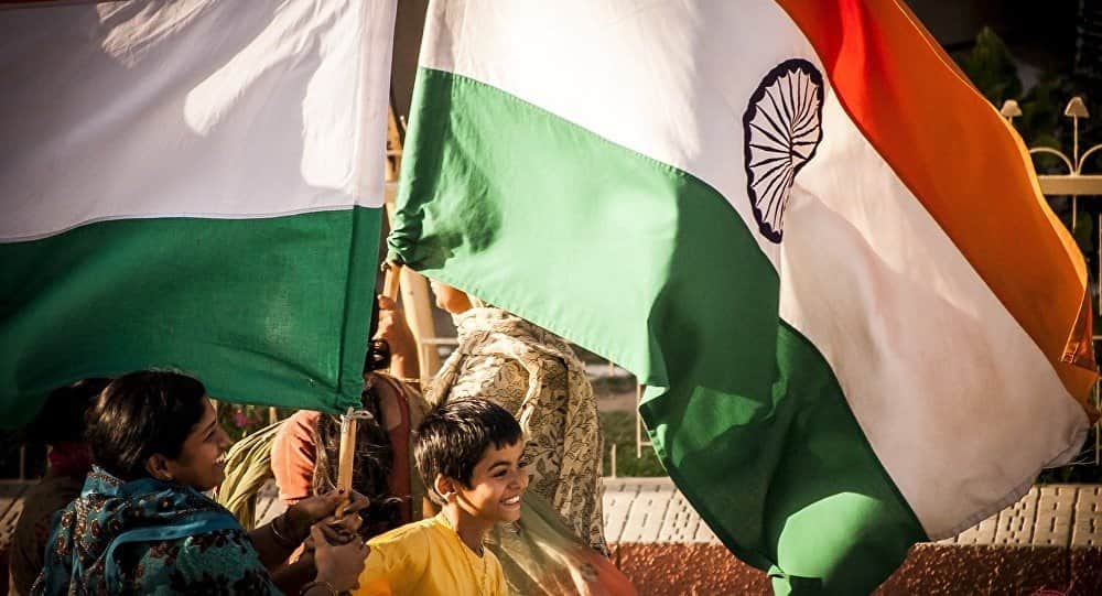 Индийцы несут флаги Индии в руках