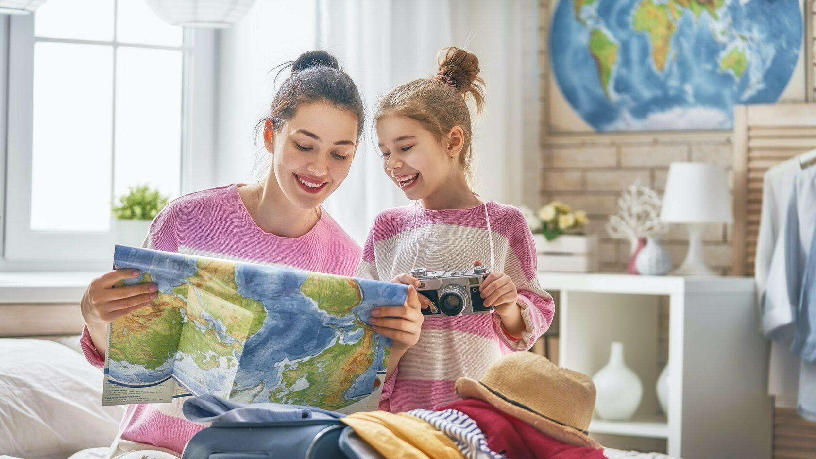 The family case. Семья планирует отпуск. Preparing for a Journey. Happy mother and daughter with Suitcase.