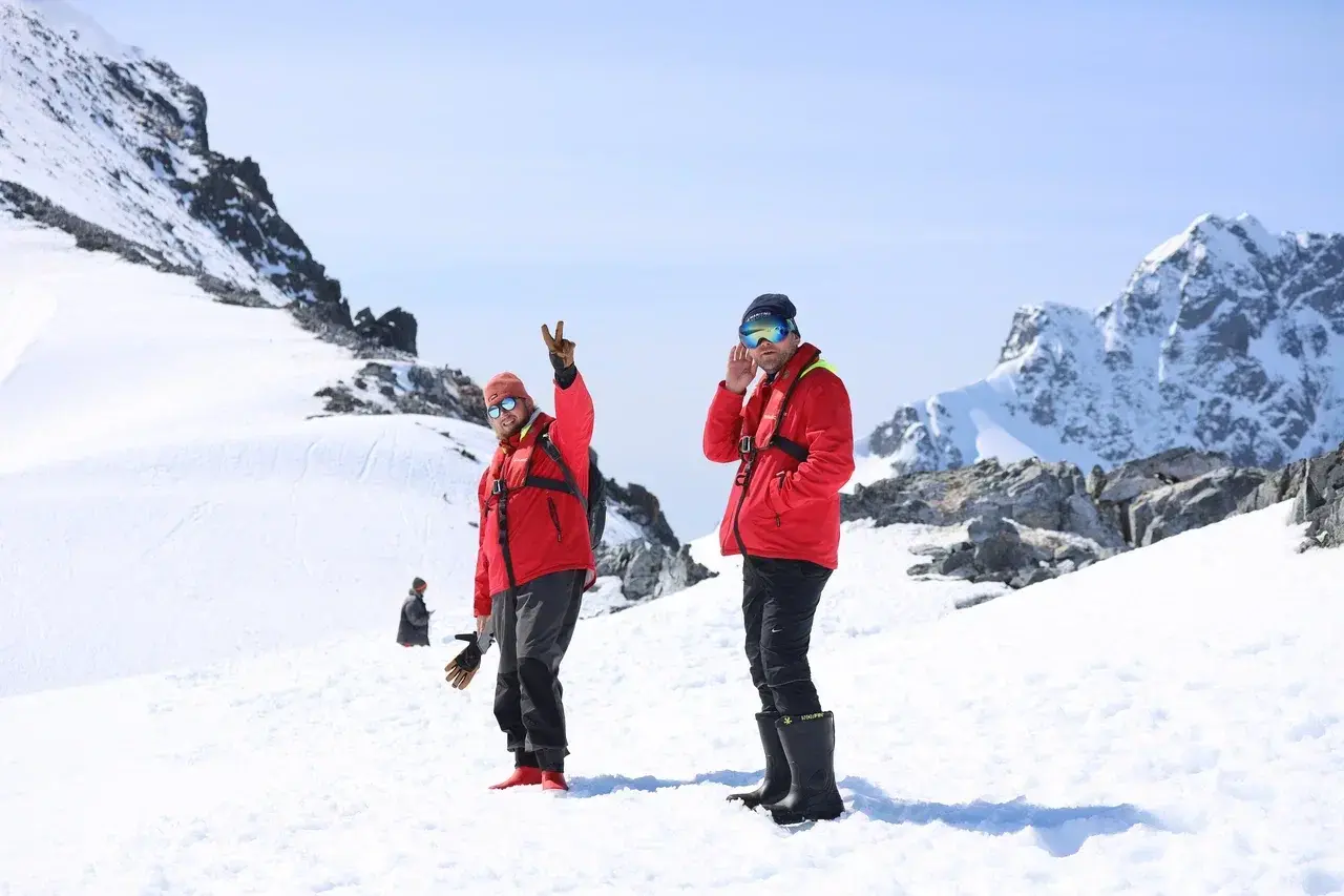 Participants of the Antarctic Science Camp exploring the snowy landscapes near Bellingshausen Station in Antarctica