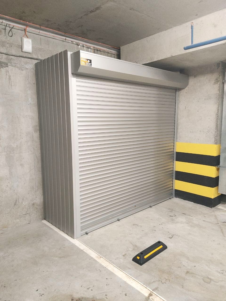 Роллетный шкаф в паркинг (MaxParking) серебристого цвета из профлиста с металлическими полками для размещения велосипедов, чемоданов и инструментов