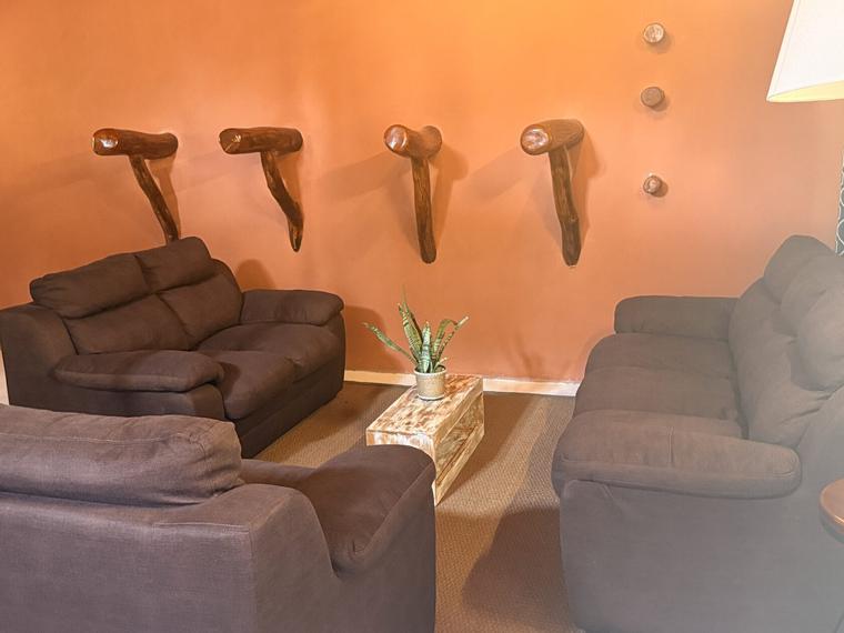 Warm, softly lit interior seating area at Vonfidel Ranch featuring leather lounge chairs, natural wood furnishings, curated wall décor, and a calm, understated atmosphere reflecting the ranch’s low-volume hospitality philosophy.