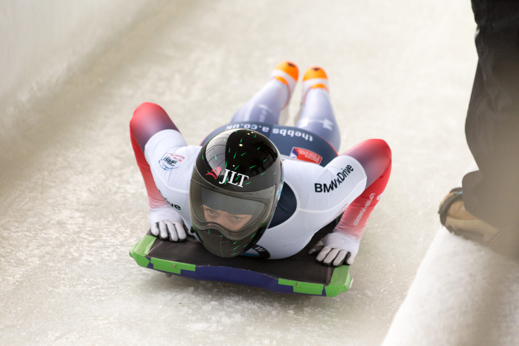 Skeleton racer in full uniform facing down a slope