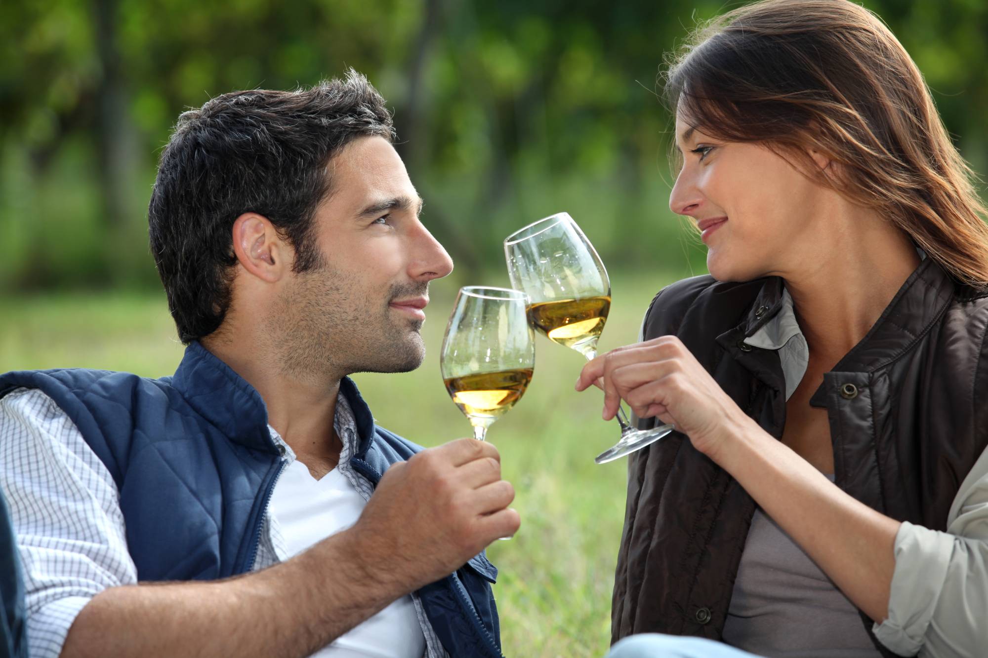 Он старше и пьет. Мужчина и женщина пьют. Мужчина и женщина пьют вино. Пара пьет вино на природе. Мужчина и женщина чокаются.