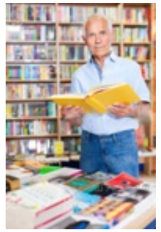 Фото 3. Описание. Пожилой мужчина в библиотеке держит книгу в руках и смотрит в камеру