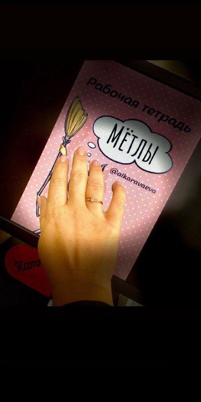 Рука с обручальным кольцом на рабочей тетради «Мётлы»