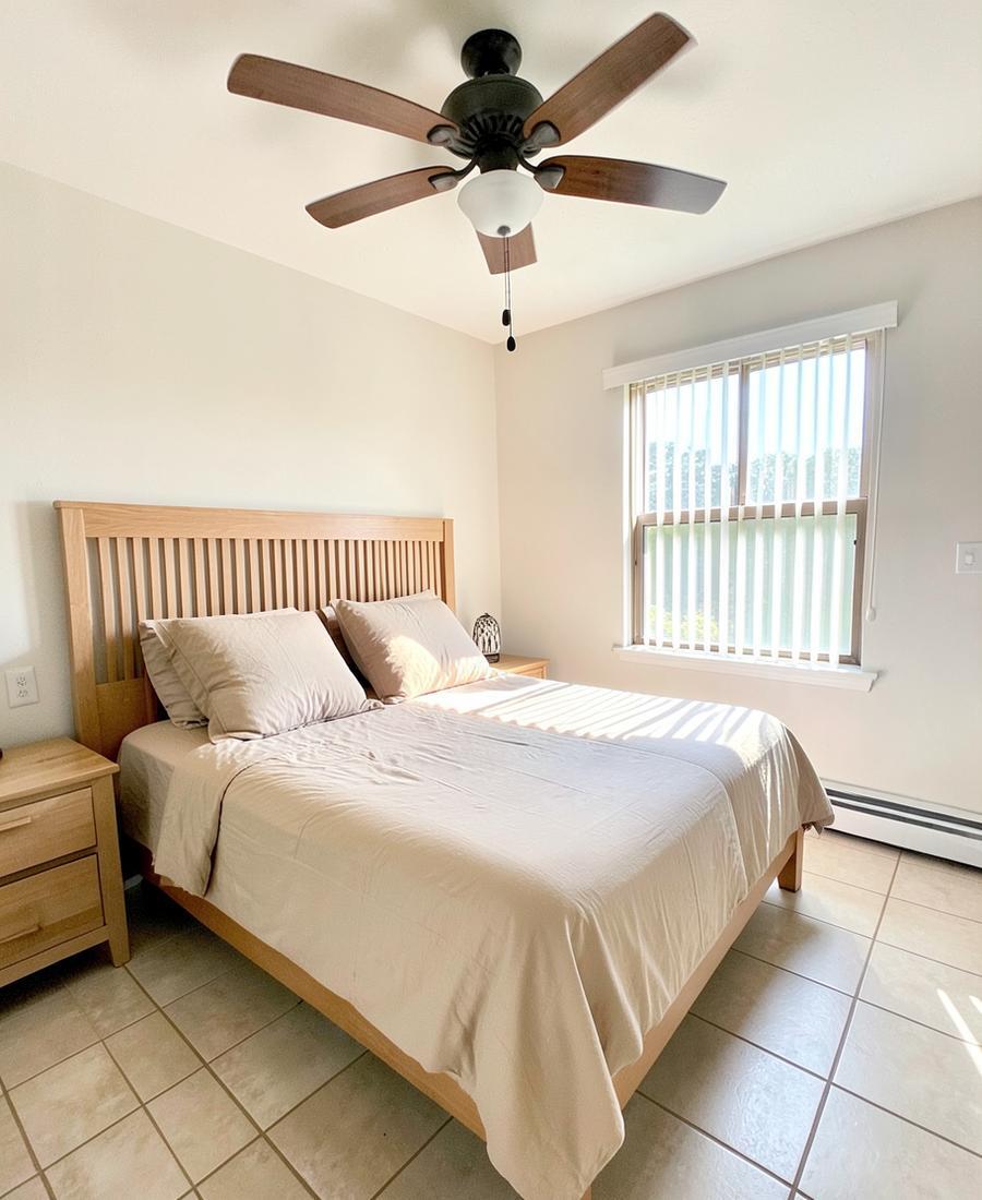 Dormitorio luminoso con cama doble y ventilador de techo