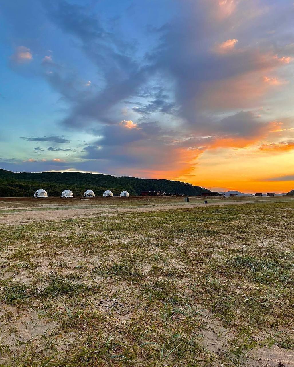 Юрты на фоне закатного неба на просторах Приморья