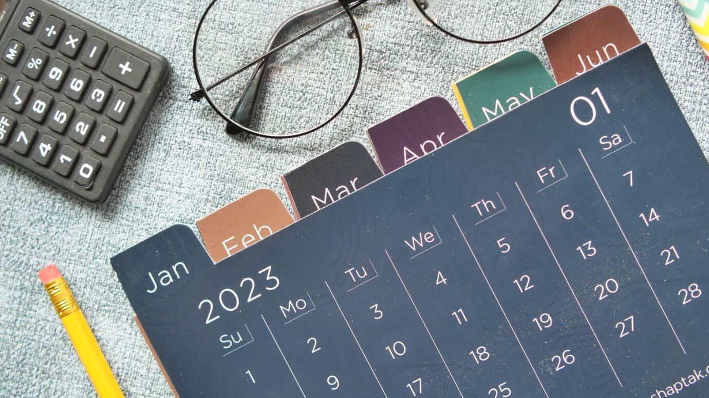 A neat calendar placed on a wooden desk