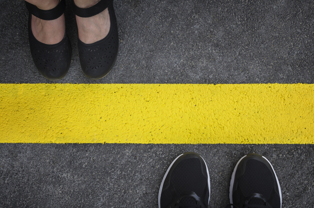 image of a yellow line and two people standing on either side of it