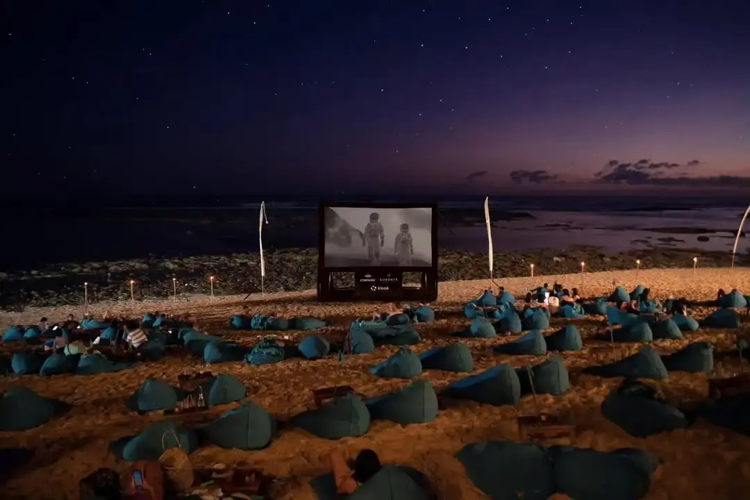 Cozy blue beanbags set up on the sand for an outdoor evening screening at Sundays Beach Club, a magical answer to where to watch a movie in Bali under the stars.