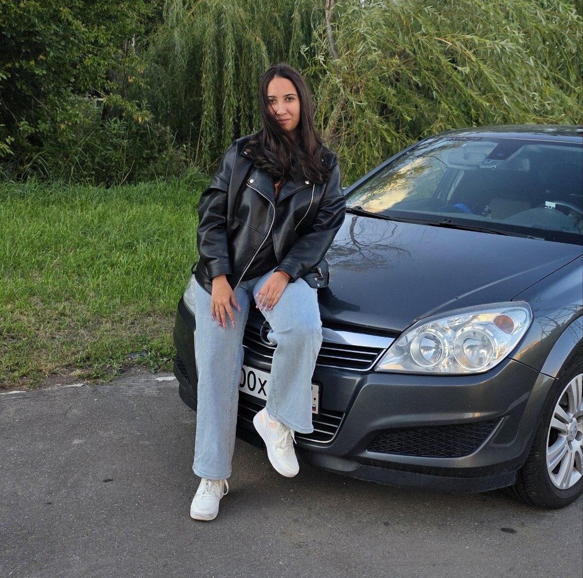 Выпускница автошколы у учебного автомобиля