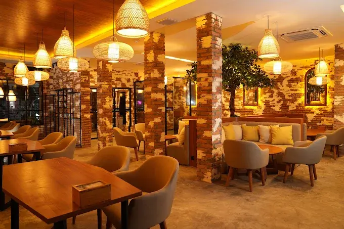 A warm and inviting view of the Eden Hookah Club Seminyak interior, featuring exposed brick walls, stylish woven bamboo lamps, and comfortable seating that's perfect for enjoying the best pizza in Seminyak.