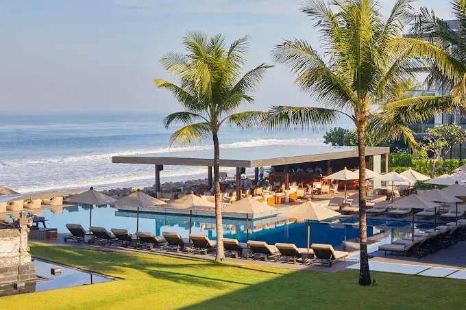 Oceanfront infinity pool and shaded daybeds at Beach Bar Alila Seminyak, a refined coastal spot among the best bars in Bali for sunset drinks.