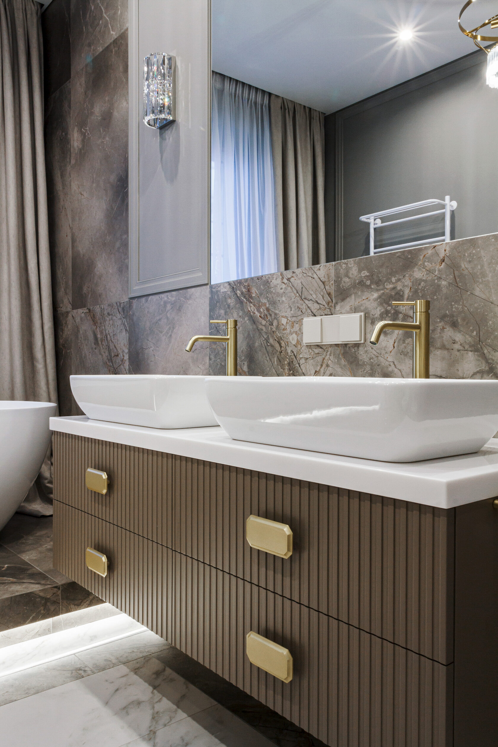 Интерьер ванной комнаты с индивидуальной мебелью и подсветкой в нише