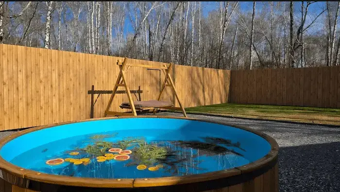 Чан с апельсинами и качелями на фоне