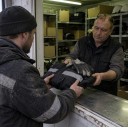 Кладовщик выдает рабочему новую спецодежду