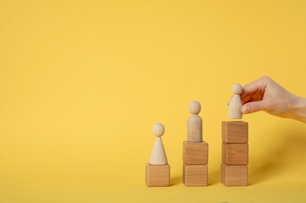 Hand putting pawn on wooden cubes