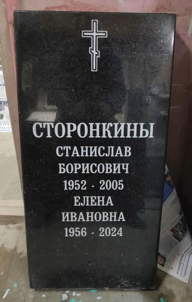 Тёмная стела после обновления оформления: крест и контрастные светлые надписи для двоих.