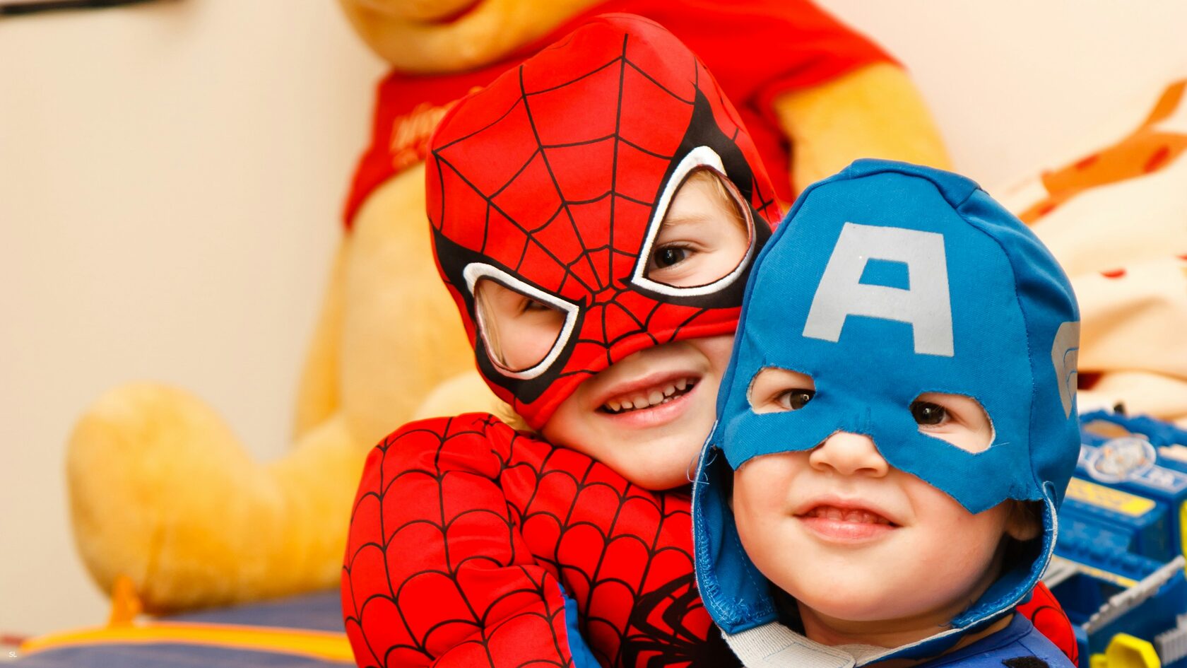 Two children dressed as super heroes smiling at the camera