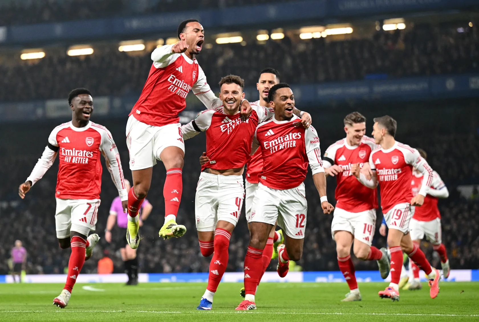 Arsenal players passionately celebrating a goal during their Premier League match against Chelsea