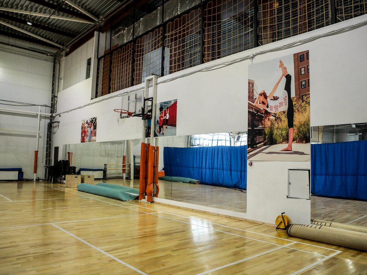 Зал гимнастики и танцев: зеркальная стена, паркет, свёрнутый ковёр