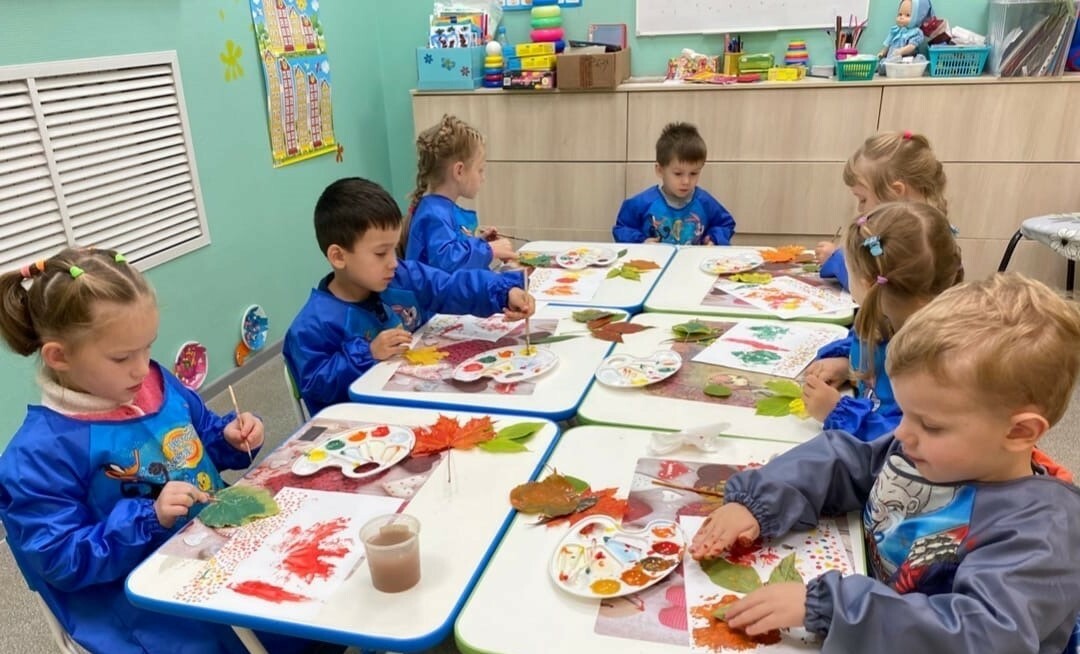 Дети делают осеннюю поделку в детском центре