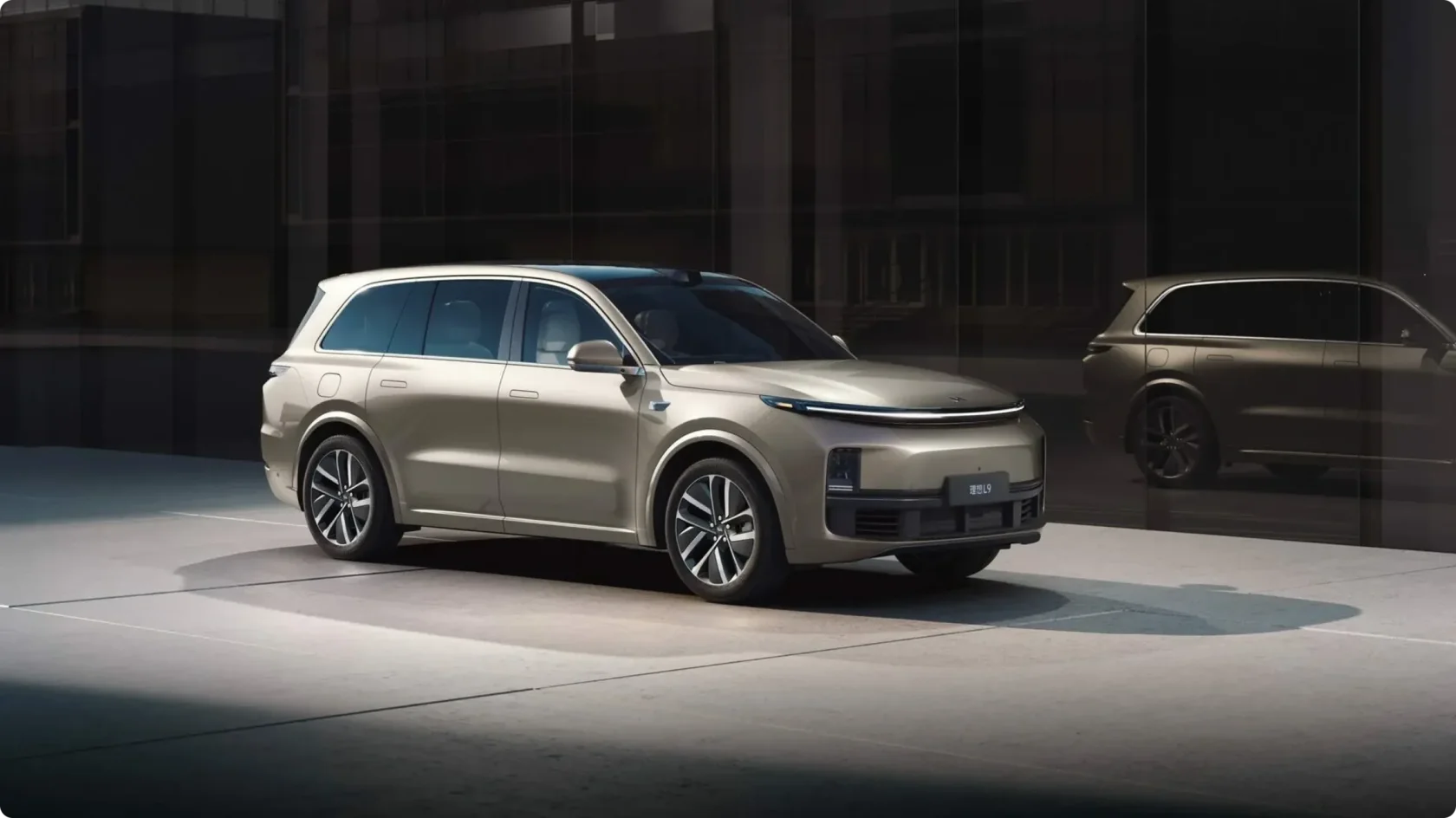 Элегантный гибридный кроссовер Li Auto L9 в песочном цвете на фоне стеклянного фасада, премиальный дизайн и аэродинамичный профиль.