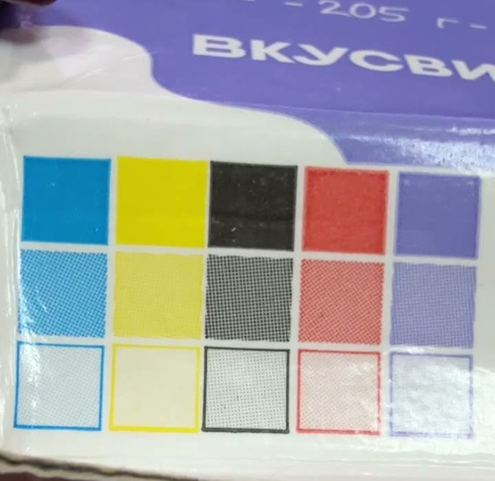Цветовая шкала на дне коробки молока «ВкусВилл»: пять столбцов — голубой, жёлтый, чёрный, красный, фиолетовый, в каждом три ступени