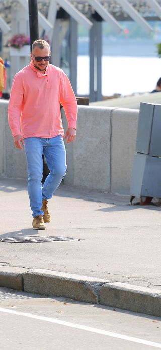 мужчина в косоворотке и джинсах на улице города