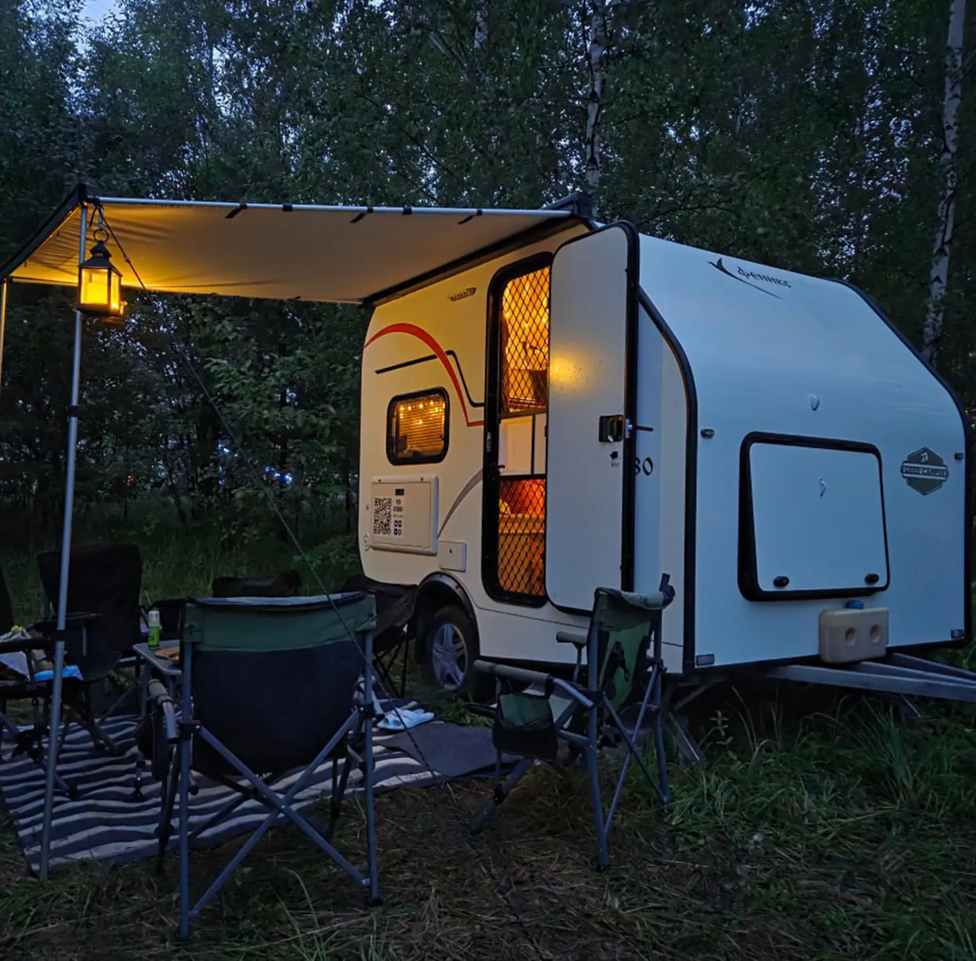Прицеп GEED CAMPER с освещённым салоном на вечерней лесной стоянке