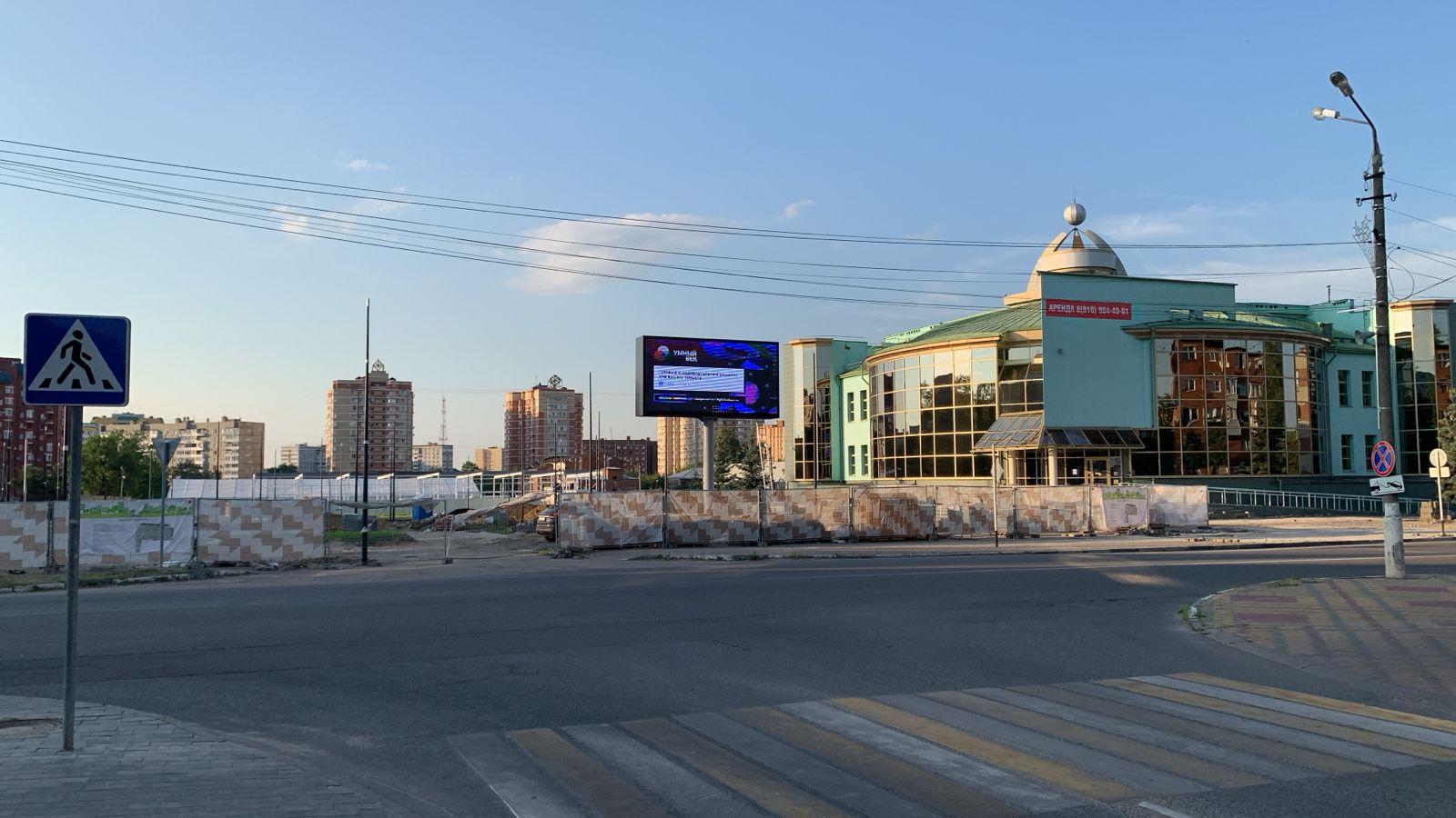 Уличный LED-экран на отдельной опоре рядом с дорогой и зданием