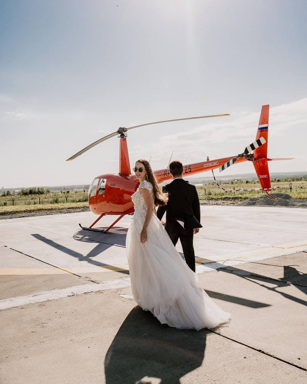 Молодожены на закате идут к вертолету