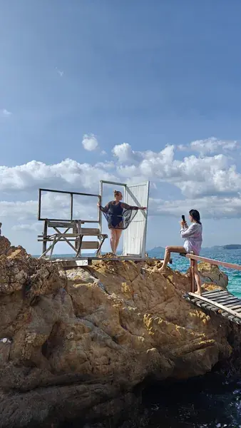 Гости у фотозоны на скалах над морем