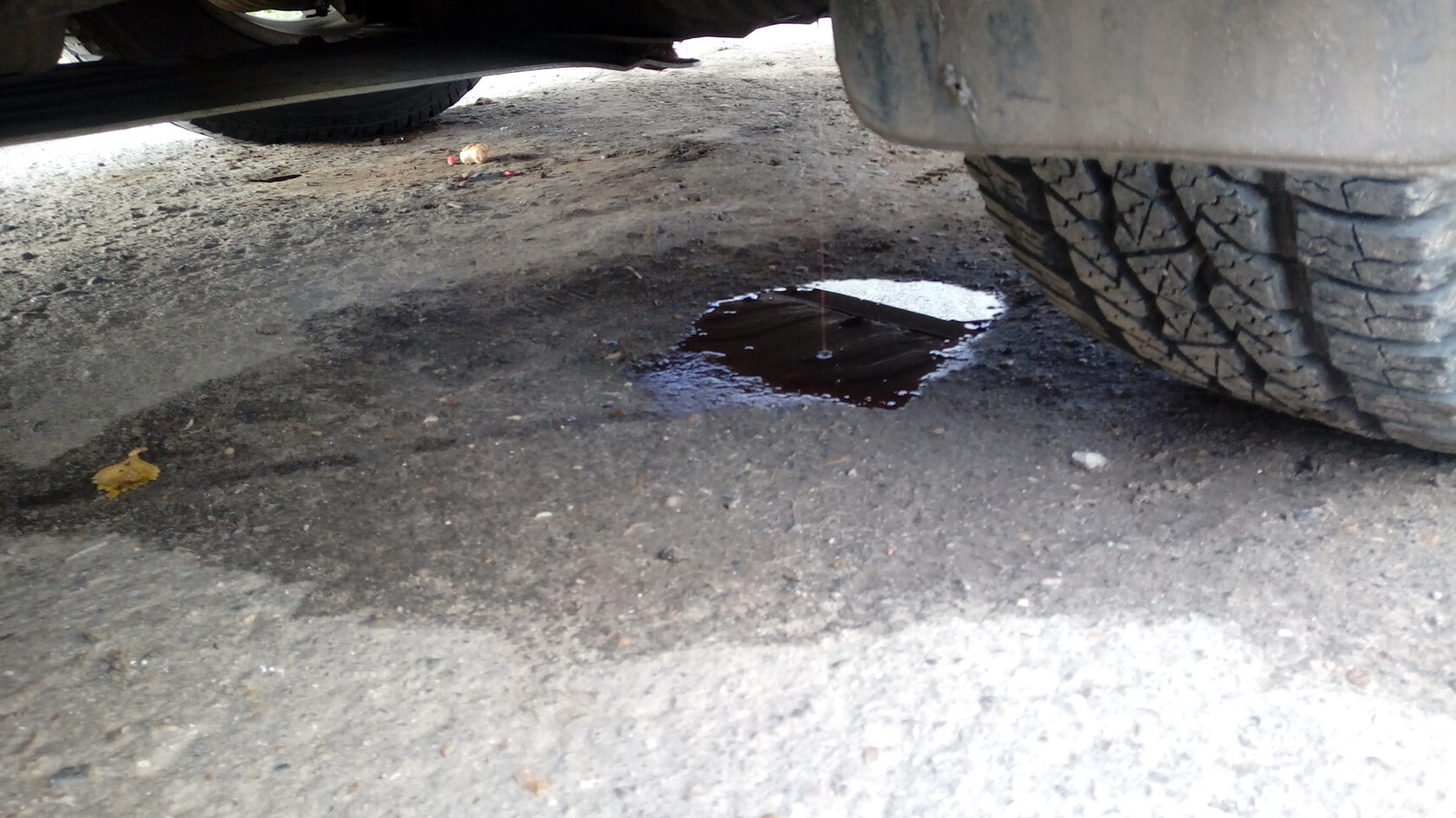 Пятно антифриза под передней частью автомобиля Volkswagen, указывающее на утечку охлаждающей жидкости.