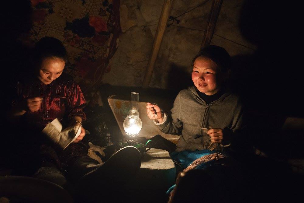 Ненцы освещают чум керосиновой лампой. Ненецкие девушки шьют обувь в чуме. Фото Елена Машкова