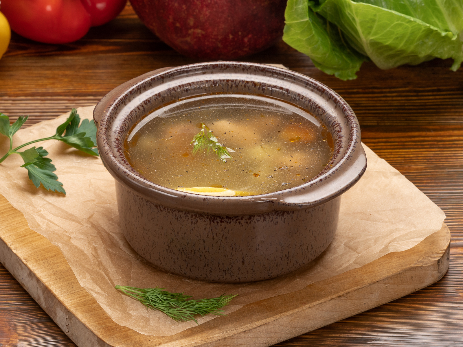 Царская уха с рыбой и зеленью в глубокой тарелке