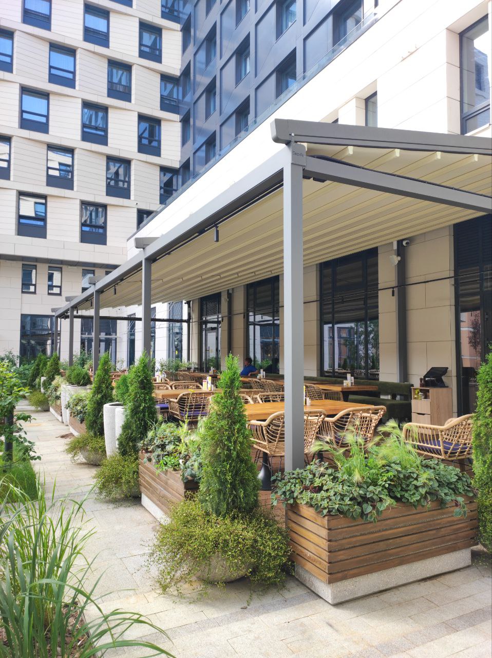 Озеленение летней террасы ресторана с кашпо и хвойными растениями