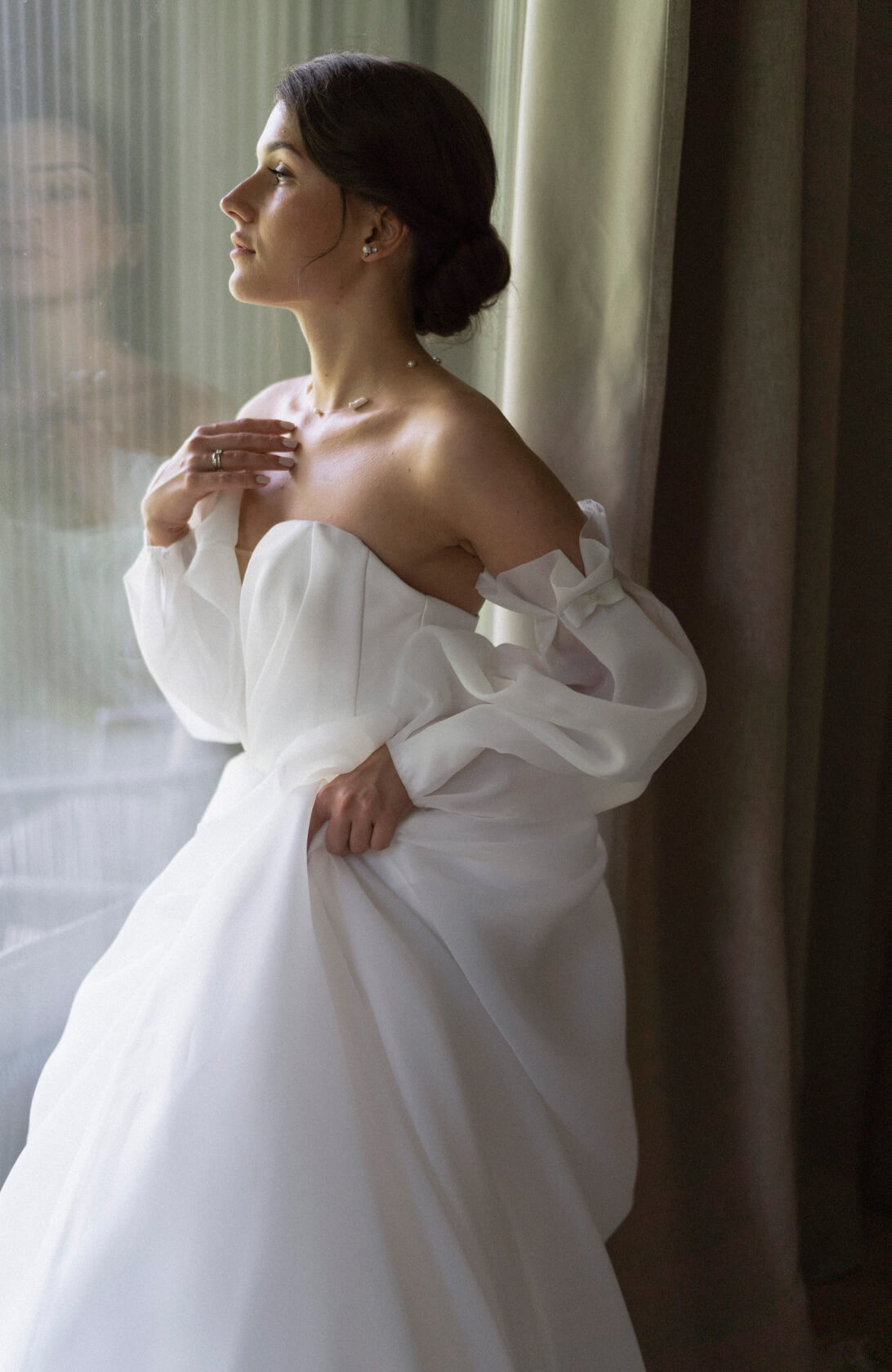 Невеста с низким пучком у окна