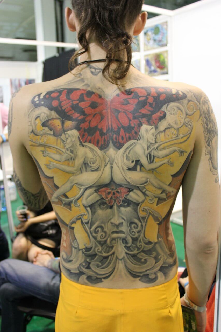 Color tattoo on the back, elves, butterflies, mystical characters, and patterns