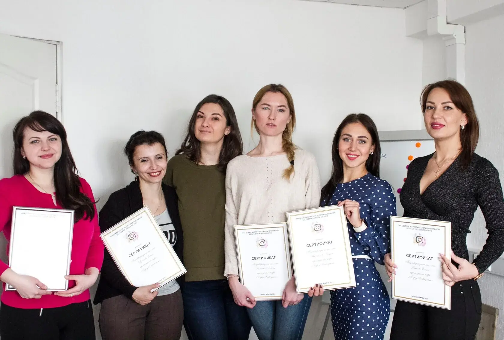 Юлия Ватутина с выпускницами курса, держащими дипломы