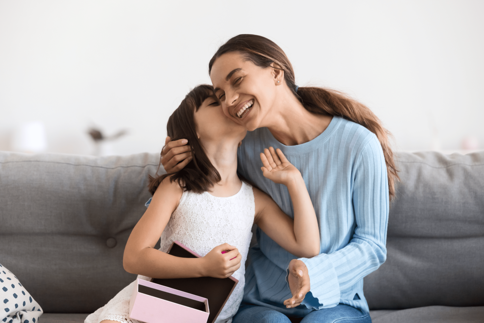 Дочь получает. Я получила дочь. Stock photo mother Kiss daughter Sofa.